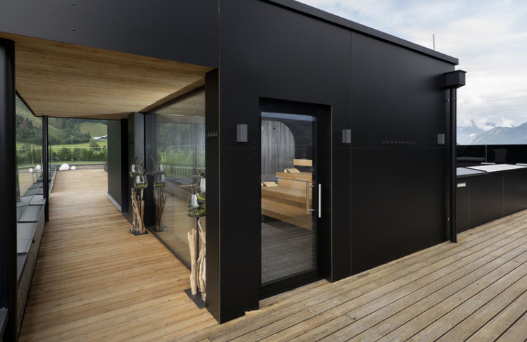 Großzügige Glasfronten geben den Blick frei auf Berge, Golfplatz und Himmel.