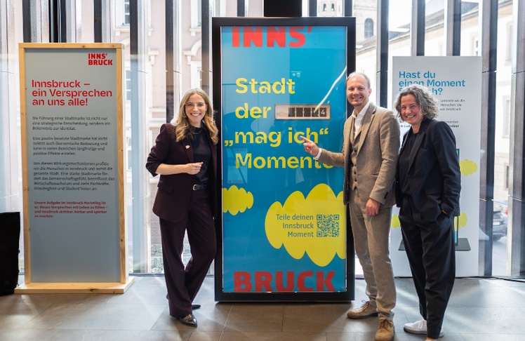 V.l.n.r.: Barbara Plattner, Johannes Anzengruber und Heike Kiesling vor der Innsbruck Momente Stele mit dem Faltblattzähler, der die Momente zählt © Alena Klinger