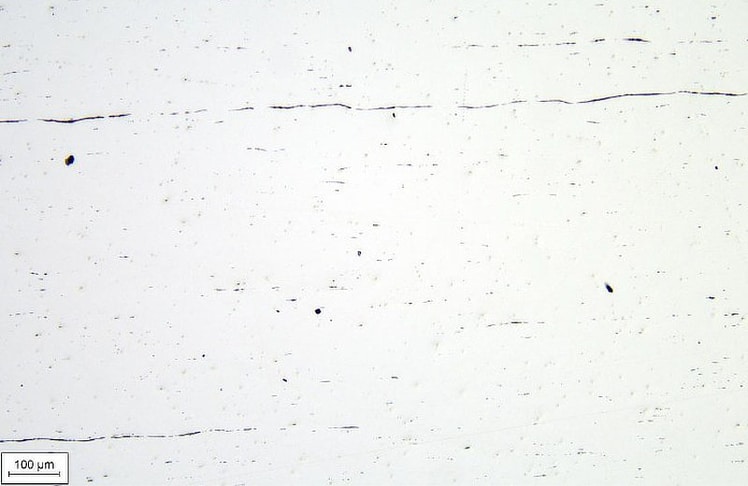 Reinheitsgradbestimmung eines Stahlstückes aus 1905. Die schwarzen Bereiche sind nichtmetallische Einschlüsse und sollten möglichst wenig vorhanden sein. Durch gezielte Maßnahmen lassen sich aber auch solche Stahlsorten verschweißen.