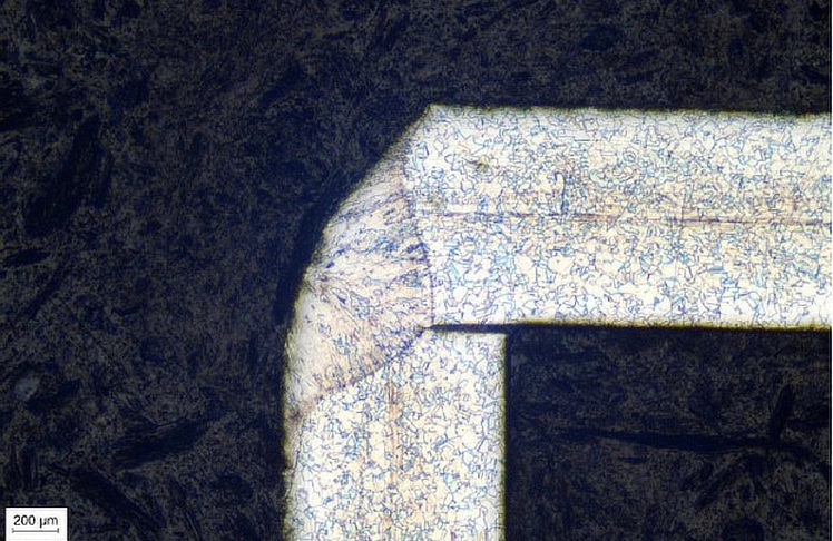 Metallographische Darstellung einer Laserschweißung (Eckstoß), welche nicht über den gesamten Querschnitt verschweißt worden ist. Es ist die Schweißzone, die nicht vollständige Durchschweißung sowie das Gefüge des Grundwerkstoffes ersichtlich.