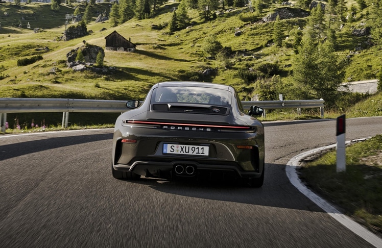 Eines der "Bergsport"-Embleme befindet sich auf der Motorraumabdeckung - das runde Signet vereint die gesamte Bergsport-Farbpalette in einem Motiv, das eine alpine Szenerie mit einer Serpentinenstraße vor einer Bergkulisse darstellen soll.  © Dr. Ing. h.c. F. Porsche AG/Porsche Holding